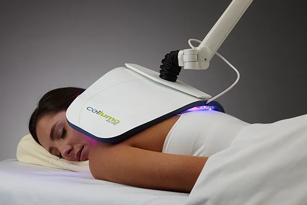 Functional Medicine Toms River NJ Celluma on Back A patient laying face down on a therapeutic bed while a celluma treatment is applied to her back