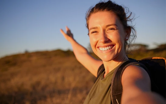 Integrative Medicine Toms River NJ Happy Hiking Woman A woman smiling broadly with arms extended while hiking.